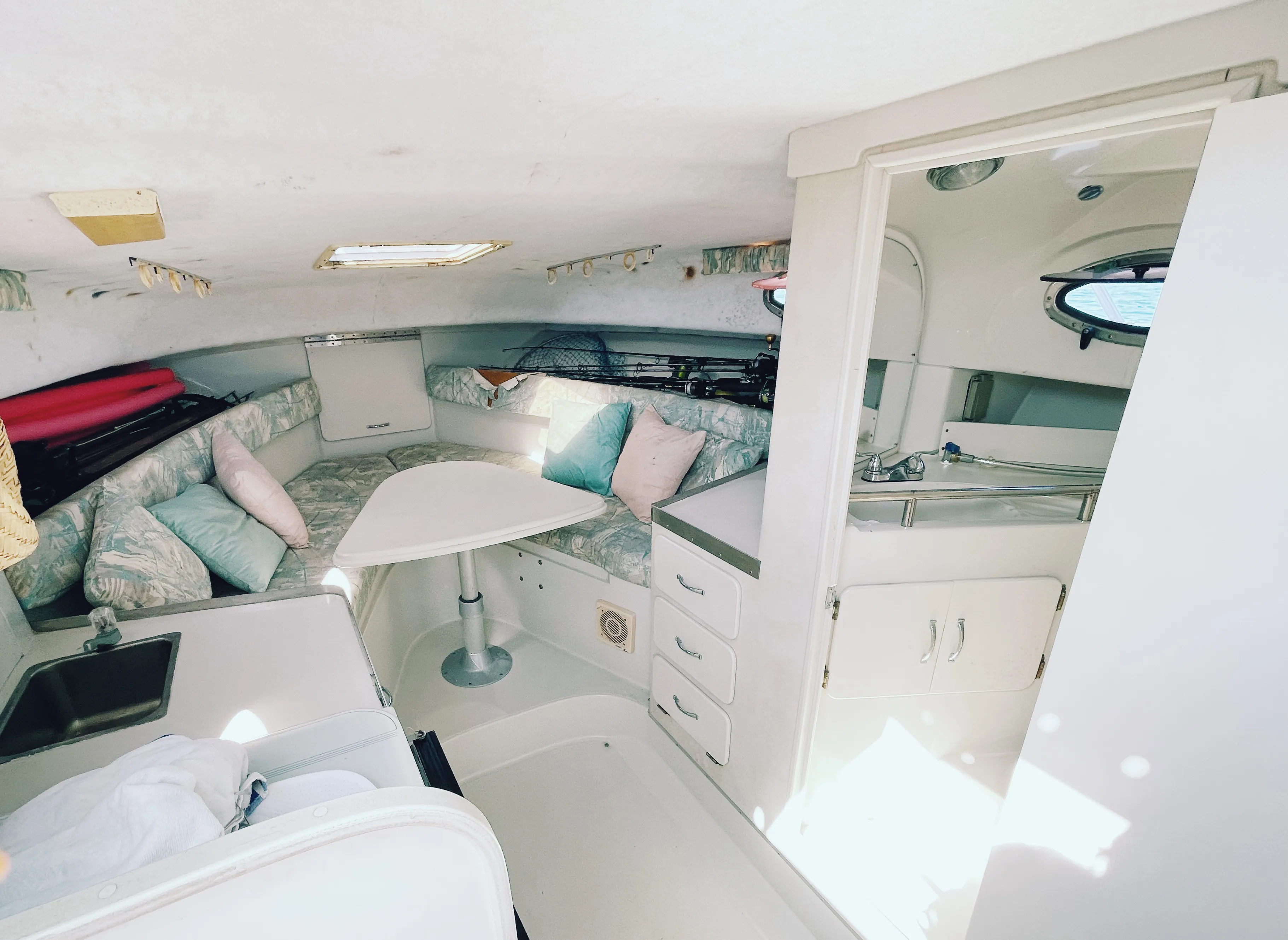 Interior cabin of the charter boat showing dinette seating, galley sink and the guest bathroom